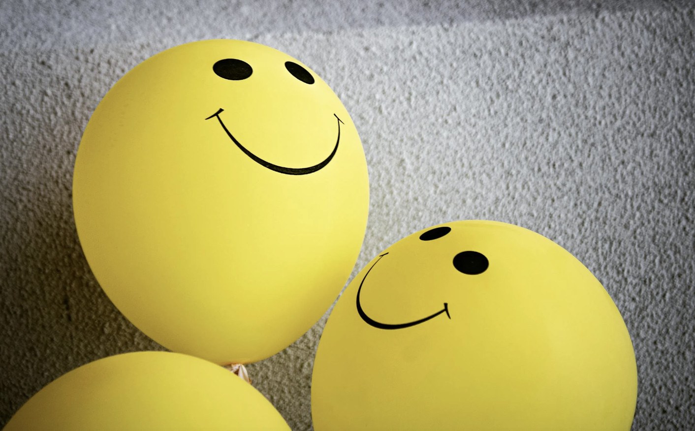 Yellow Smiley Emoji Balloons on Gray Surface.