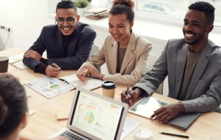 A group of smiling coworkers in a meeting.