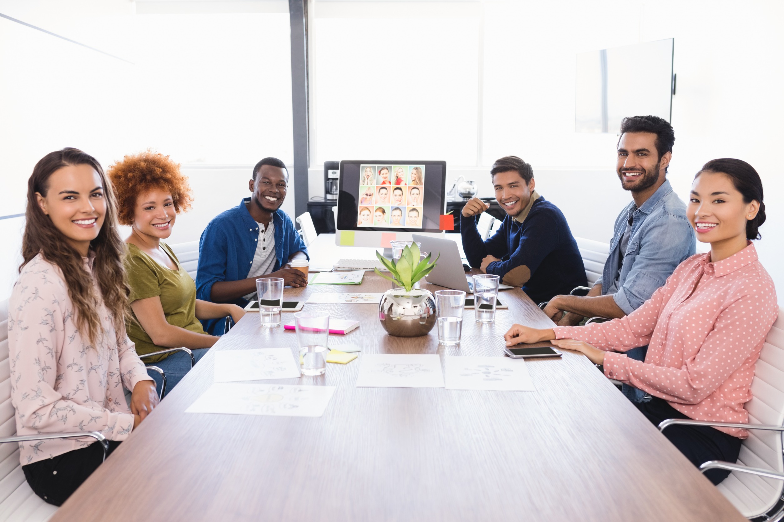 Six people sitting around a table having a meeting