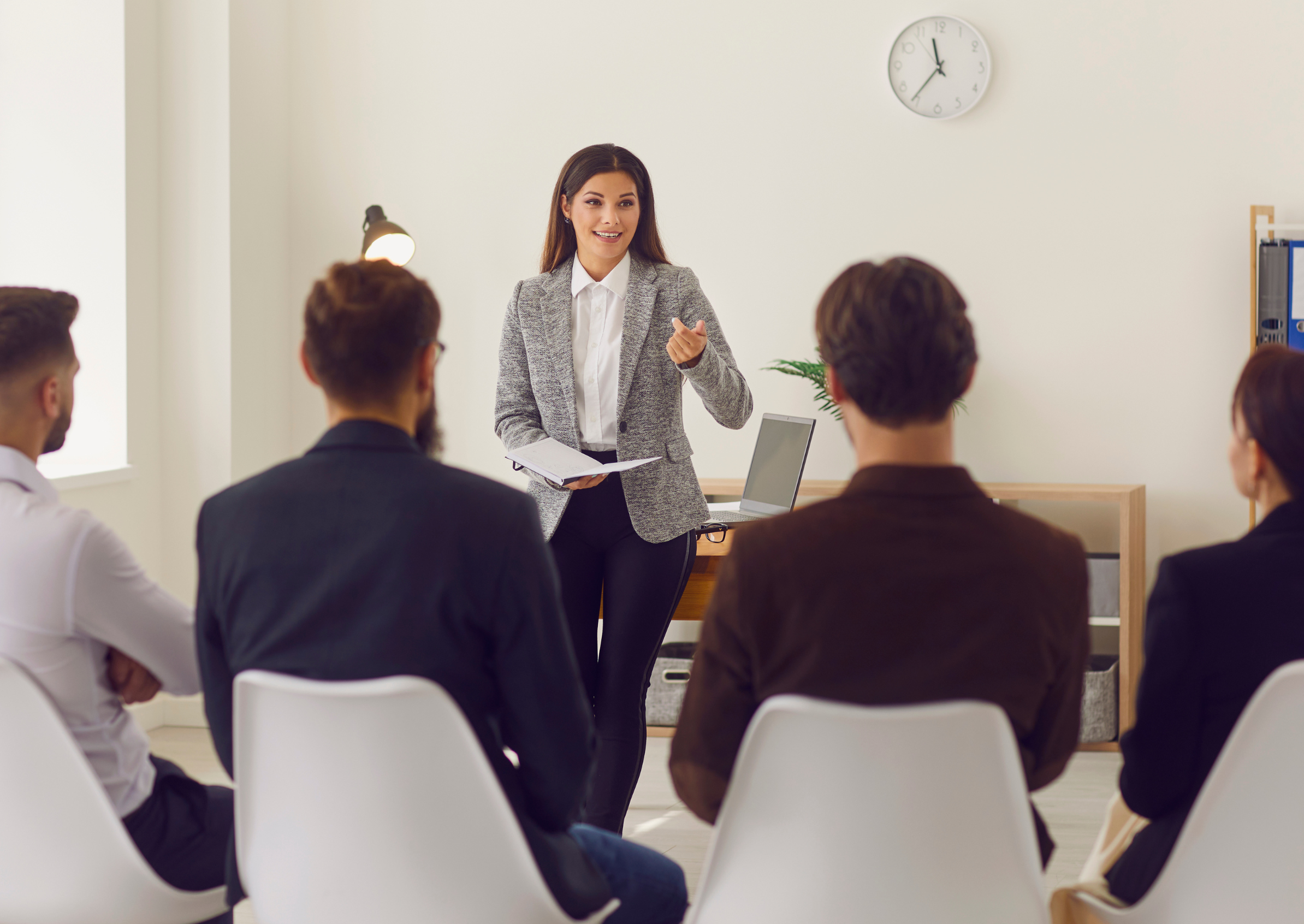 Image of a woman presenting in front of a group of people. 