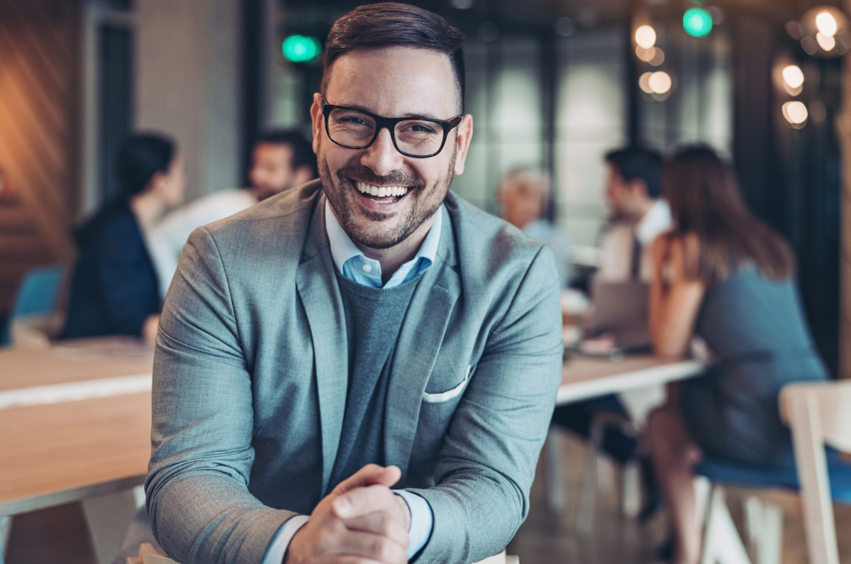 A man in the office smiling happily. 