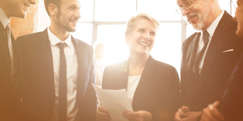 A woman leader holding a paper delegating roles to others. 