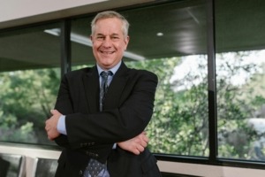 A man in a suit at an office looking confident. 