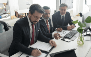 Three business man working on strategic planning at a desk in an office.