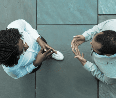 An overhead shot of two coworkers in a discussion.