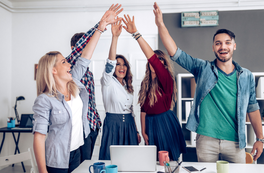 A photo of employees giving each other a high five. 